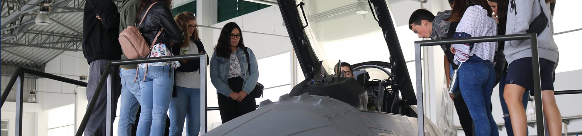 Jovens observam as explicações sobre uma aeronave