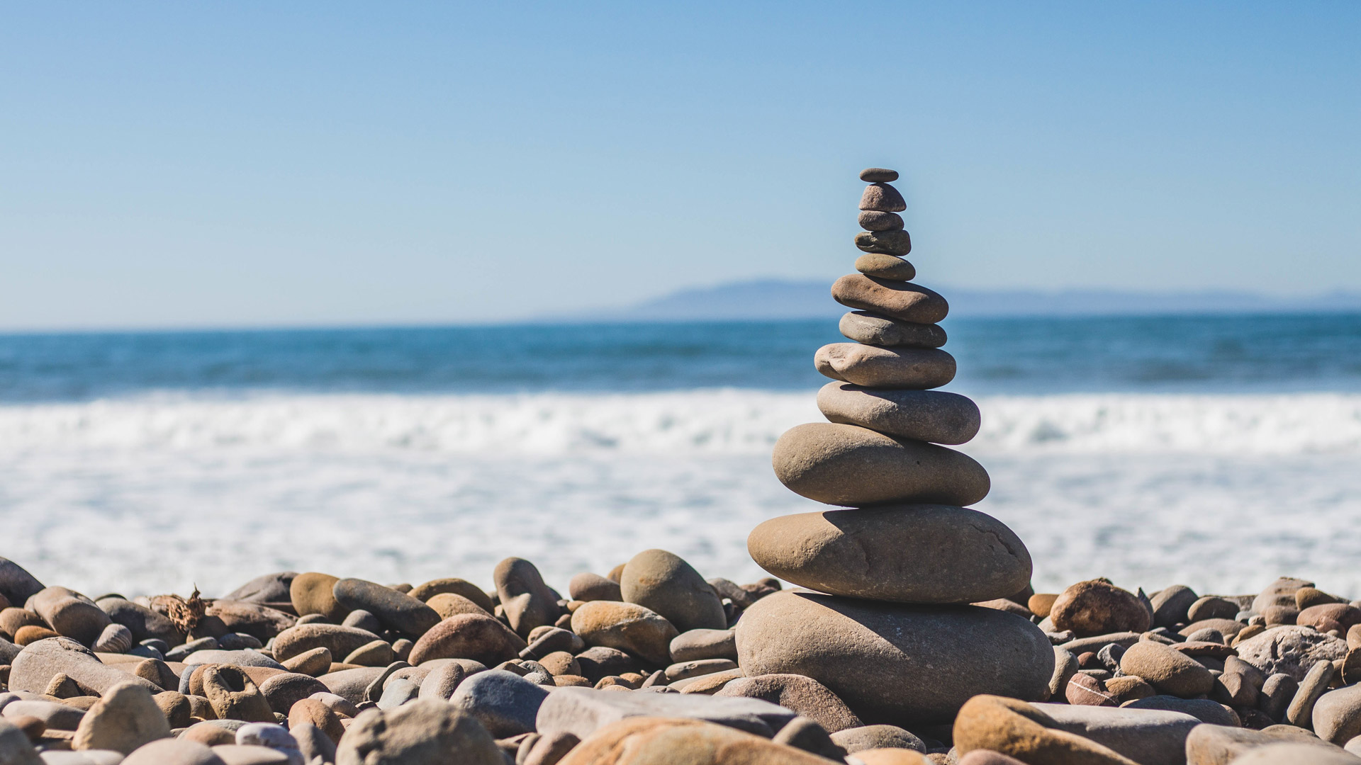 vislumbre de mar e pequenos seixos, com alguns em equilibrio