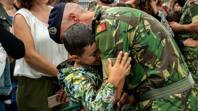 militar abraçado a criança